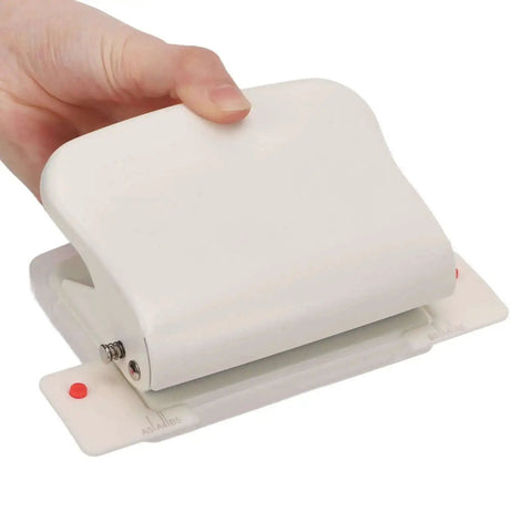 Hand holding Heavy Duty Metal Hole Punch For Home Office Desk, 10 hole punch in white with storage and guides.