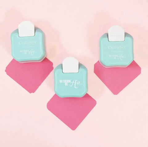 Three blue 3 in 1 Corner Rounder Punches for Scrapbooking and Card Making with Three Radius Settings on a pink background