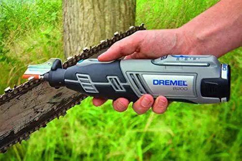 Chainsaw Sharpening Kit For Rotary Tool With Angle Guide Attachment And Grinding Stones Set Pro Grade Sharpness Fast And Easy Sharpening For Chains Includes Four Stone Sizes Extends Chain Life And Versatility Dremel 1453 Compatible in use sharpening a chainsaw blade outdoors with grass background.