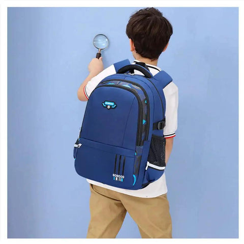 Boy with durable waterproof rolling backpack for boys ideal for elementary and middle school, blue design, side view.