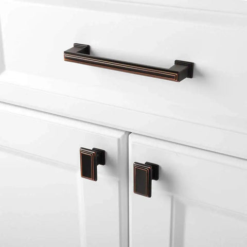 10 Pack 5 Inch Cabinet Pulls In Oil Rubbed Bronze installed on white kitchen cabinets showing elegant finish.
