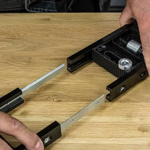 Close-up of All-In-One Adjustable Door Hinge Jig Installation Kit For 2 Ft 6 In To 9 Ft Doors in use on wooden surface