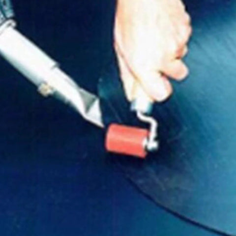 Heavy duty silicone seam roller with red roller and white handle held in hand