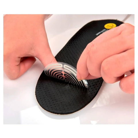 Therm-IC heating element pair being peeled onto a black perforated sport insole.