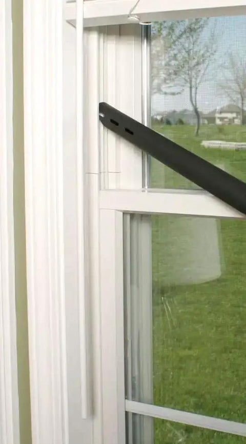 Black extension hose of the Upright and Canister Vacuum Extension Hose and Attachment Kit near a window frame.