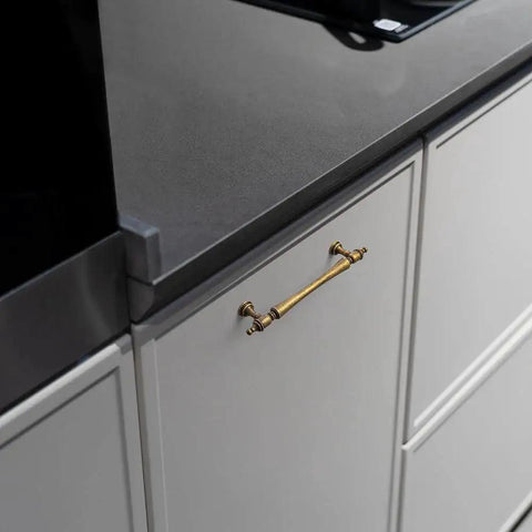 Six Pack 5 Inch Antique Brass Cabinet Pulls With Ornate Tapered Handles Decorative Finials And Sculpted Detailing installed on kitchen cabinet
