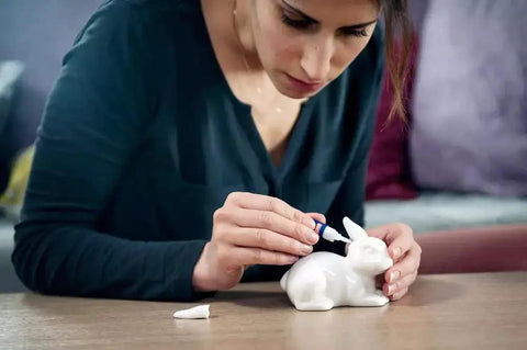 Person using Clear Quick Dry Super Glue For Plastic Wood Metal 2 Pack Precise Piercing Tube to repair ceramic rabbit