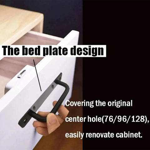 Hand holding matte black cabinet handle with 5 inch hole center on drawer, showing installation.