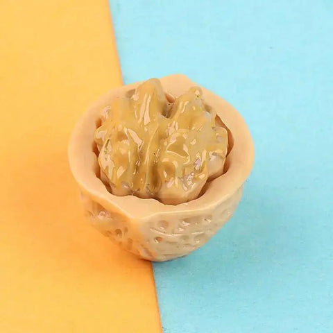 Close-up of a resin walnut from 15-Piece Realistic Miniature Nut Set For Dollhouses, highlighting detailed texture and lifelike appearance.