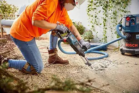Person using Bosch Bulldog Extreme 1 Inch SDS Plus Rotary Hammer for concrete drilling, showcasing 8 Amp motor performance