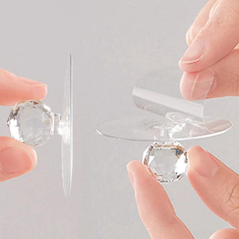 Hands holding Crystal Diamond Drawer Knobs Self Adhesive Clear Acrylic Pull Handles for drill-free installation on cabinets and furniture.