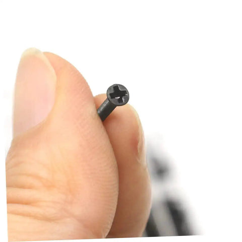 Close-up of a black flat head screw from the 18 Spec Miniature Screw Set Kit With Flat Head Screws In Transparent Case For Glasses And DIY Repairs.