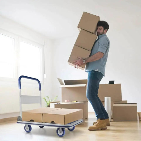 Man carrying boxes next to a Heavy Duty Foldable Push Cart Dolly With 330 Lb Capacity Collapsible Hand Truck in a room