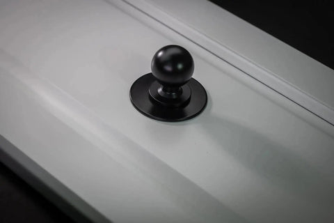 Matte Black Cabinet Knobs Four Pack With Wide Backplates installed on a white cabinet door, large ball knob visible