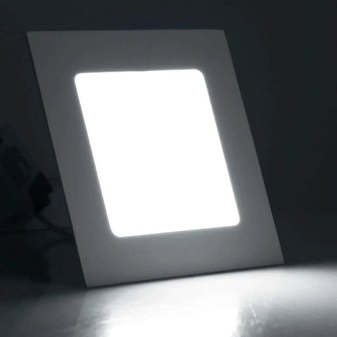 Square LED panel light emitting bright white light against a dark background