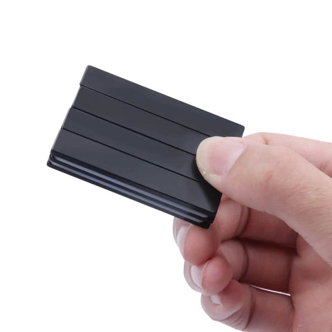 Neodymium bar magnet, epoxy-coated, black, 60 x 10 x 3 mm, close-up held in hand