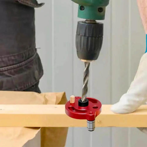 Centering Doweling Jig And Dowel Drill Guide in use with drill, red aluminum alloy, for precise straight holes in wood panels.