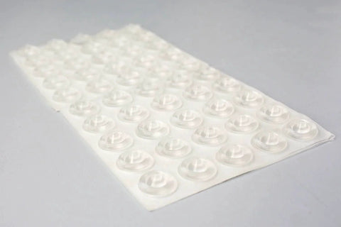 Sheet of sound dampening door bumpers, half inch dia, 5mm height, soft durometer, clear adhesive, 100 count, angled view