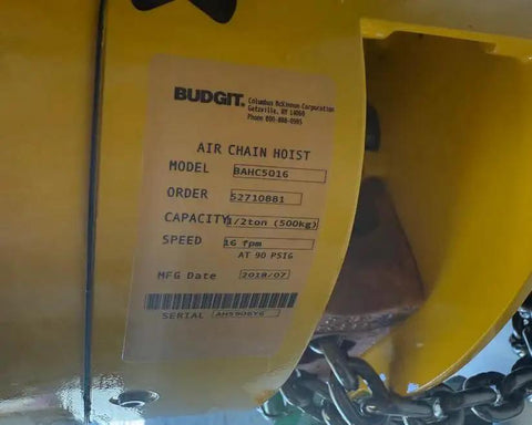 Close-up view of a yellow air chain hoist showing model and capacity label.