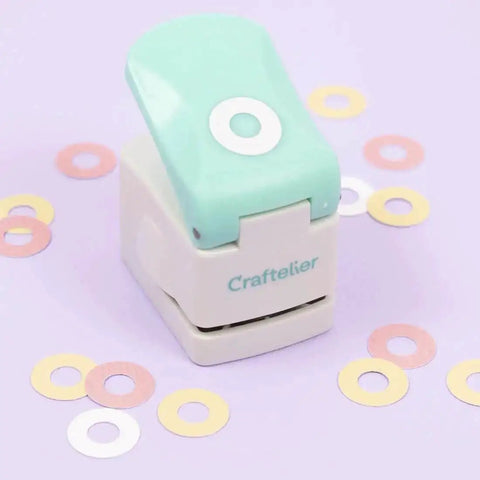 Circle Punch With Reinforcing Ring And Snap Lever for paper crafting, shown with turquoise lever and decorative grommets.