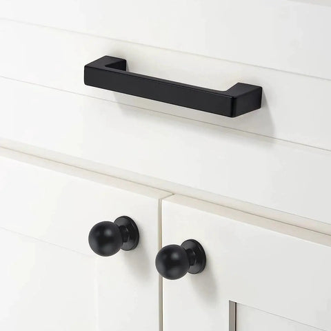 Matte black cabinet pull installed on white cabinet; 20 Pack Matte Black Cabinet Pulls Center To Center Three And Quarters Inches With Four Point Four Inch Overall Length Half Inch Inches One And Quarter Inch Projection Includes One And One Quarter Inch Screws.