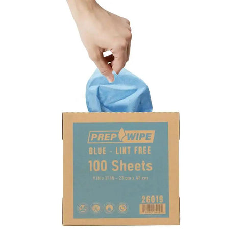 Hand pulling a blue towel from a box labeled Heavy Duty Lint Free Cleaning Towels For Auto Body And Industrial Prep, Solvent Resistant Wipes, 100 Pack, 9x17 In.