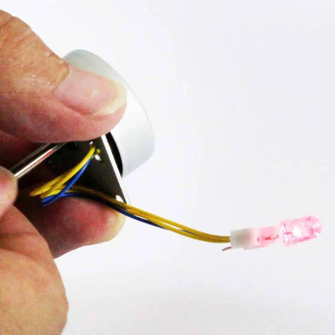 Person holding Mini 3 Phase Brushless AC Generator For Hands-On Science DIY Teaching Kit with attached LED light