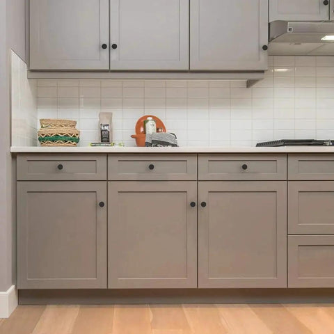 18 Pack 1-1/5 Inch Matte Black Round Cabinet Knobs Zinc Alloy Heavy Duty Pulls on kitchen cabinets with gray finish.