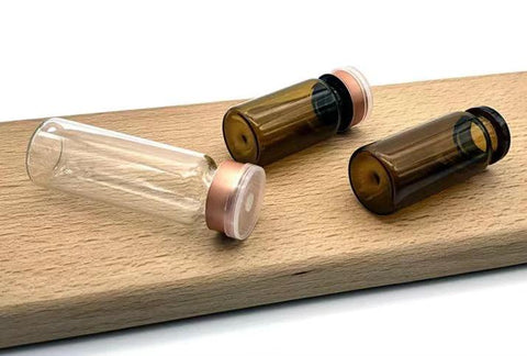 Three 10ml glass lab vials: clear and amber borosilicate glass with flip-off aluminum caps
