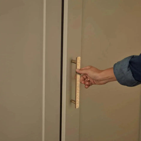 Hand pulling Luxurious Zinc Alloy Cabinet Handle with 5 Inch Hole Centers in Champagne Bronze on a wardrobe door.