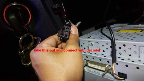 LEXXSON optic fiber decoder module, black connector with orange wire held in hand near car stereo unit.