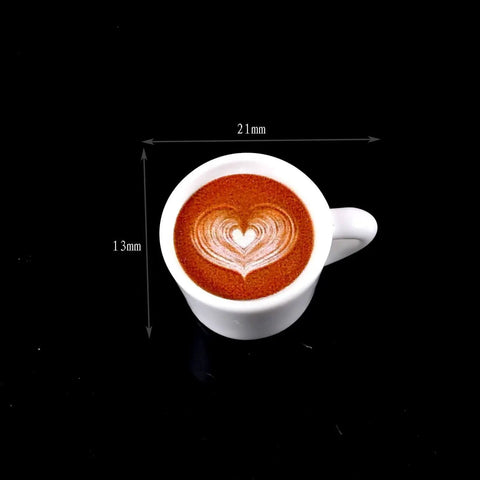 Top view of a white cup with heart latte art and dimensions 21mm x 13mm on black background.