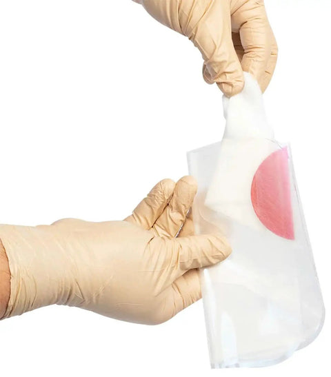 Hands holding Twin Pack HyFin Vent Chest Seal for Trauma and Wound Care, showing three-channel pressure relief vents.