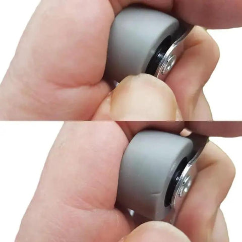 Close-up of fingers holding 25mm rubber wheel from Pack Of 20 25mm Rubber Wheels Set With Metal Plates And Plastic Double Castors For Furniture.