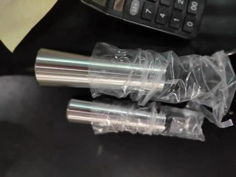 Two silver Morse taper adapters in plastic wrap; reducing drill sleeves for lathes and drill presses.
