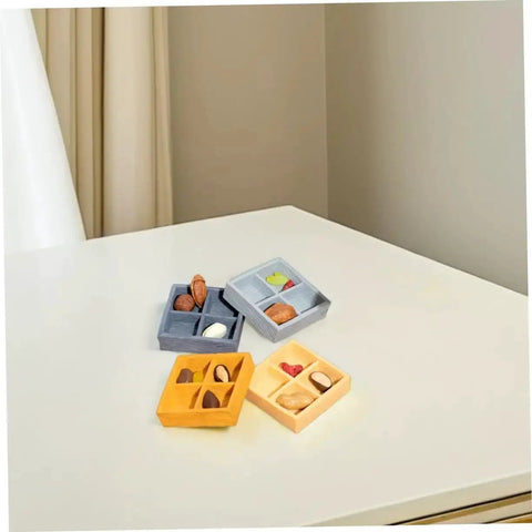 Four 4 Piece Miniature Storage Box for Dollhouse Resin Four Grid Organizer in assorted colors with candy and nuts on a table