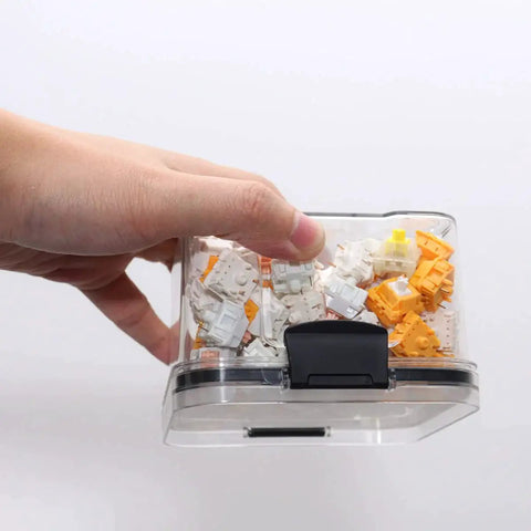 Hand holding a Durable Sealed Switch Storage Box For Mechanical Keyboard Switches Transparent 460ml Clear Plastic Case