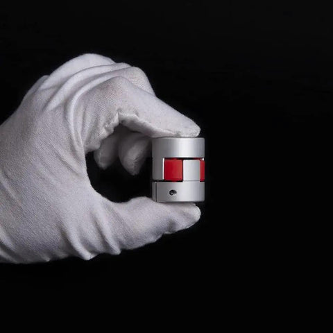 Beefy Durable Aluminum Flexible Shaft Coupling D25 L30 For 5 To 8mm Shafts in gloved hand, showing red dampening element.