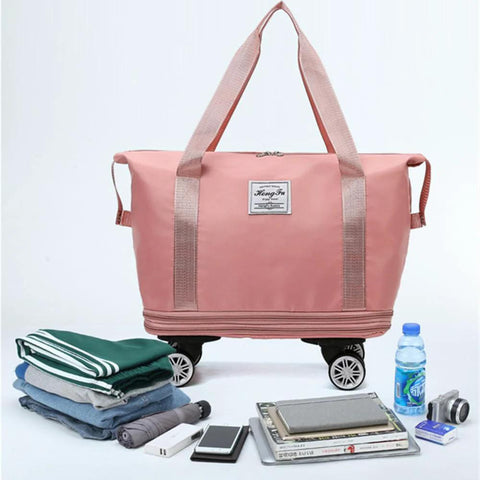 Expandable Travel Tote Bag With Trolley Sleeve And Wheels, Waterproof Oxford Duffel, shown with folded clothes, tablet, and water bottle