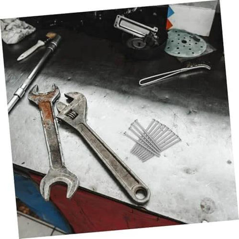 Stainless Steel Countersunk Flat Head Self Tapping Screws for Furniture Assembly on workbench, next to wrenches and tools.