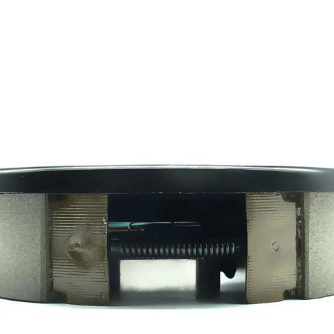 Electric trailer brake assembly inside a black housing; visible coil spring and metal components.