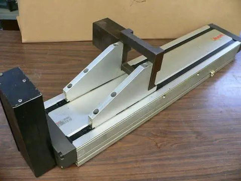 Single Pre-owned Robotic Linear Unit, Precision Automation Guide Rail with Slide Block on a wooden surface, used motion stage for automation.