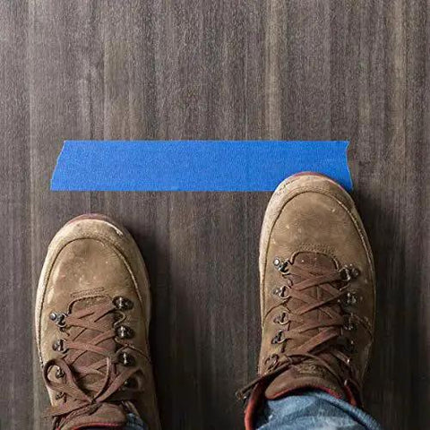 Clean Release Blue Painter's Tape 0.94 Inch Wide 60 Yards For Sharp Lines placed on wooden floor with boots visible