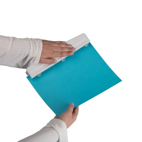 Hands using a Metal 3 Hole Punch For White Paper, 10 Sheet Capacity, Built Tough Desk Side Workhorse on blue paper