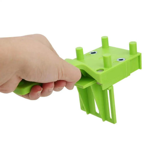 Hand holding a green Woodworking Doweling Jig Kit For Precise 6mm 8mm And 10mm Holes 8 Piece Drill Guide Set With Pro Grade Adjustable 0 To 50mm Border Drilling For Furniture Assembly And DIY Projects tool.