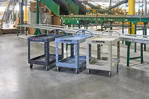 Three utility carts in a warehouse setting, showcasing the Two Shelf Foam Utility Cart With Lipped Shelves And Ergonomic Handle Black 500 Lb Capacity Durable Rolling Cart For Warehouse Garage Cleaning And Manufacturing Environments Heavy Duty Construction For Long Lasting Service In Demanding Workspaces.
