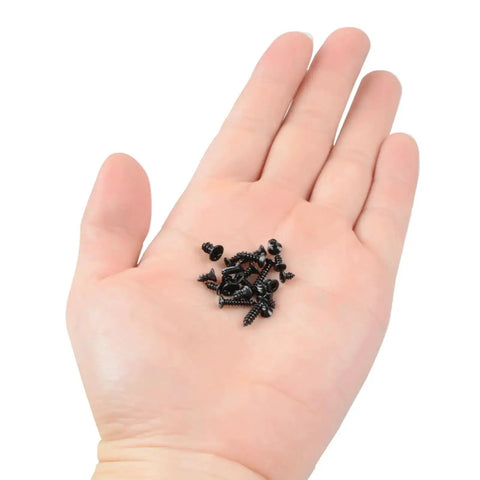 Hand holding black screws from 300 Piece Black Laptop Screw Replacement Kit With Countersunk Self Tapping Screws KA2 KA2.6 KA3