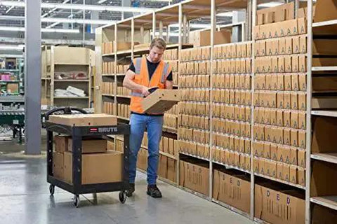 Worker using Two Shelf Foam Utility Cart With Lipped Shelves And Ergonomic Handle Black 500 Lb Capacity Durable Rolling Cart in warehouse