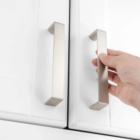 Hand installing 10 Pack 5 Inch Brushed Nickel Cabinet Pulls Satin Silver Cabinet Handles on white kitchen drawers