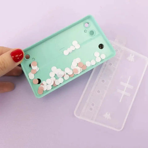 Hand holding mint waste tray filled with punched paper discs, part of 2 Hole Puncher With Waste Tray, 10 Sheet Capacity, Metal Puncher.